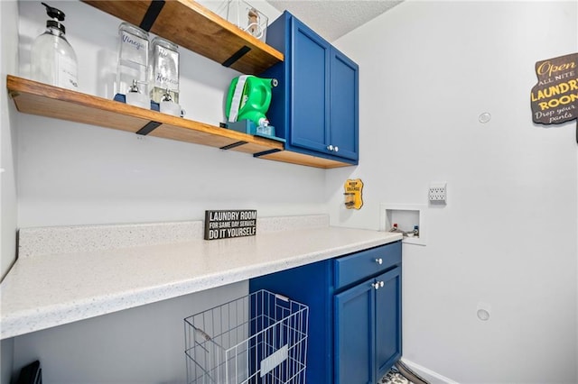 washroom with washer hookup, cabinet space, and a textured ceiling