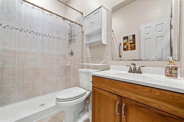 bathroom featuring vanity, tile patterned floors, toilet, and tiled shower