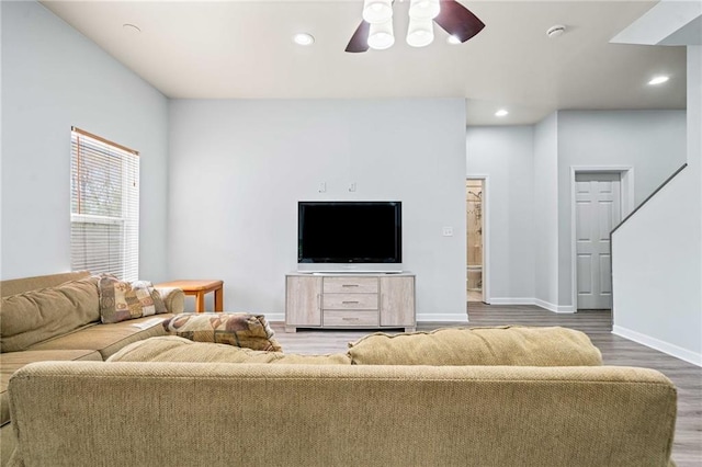 living area with a ceiling fan, recessed lighting, wood finished floors, and baseboards