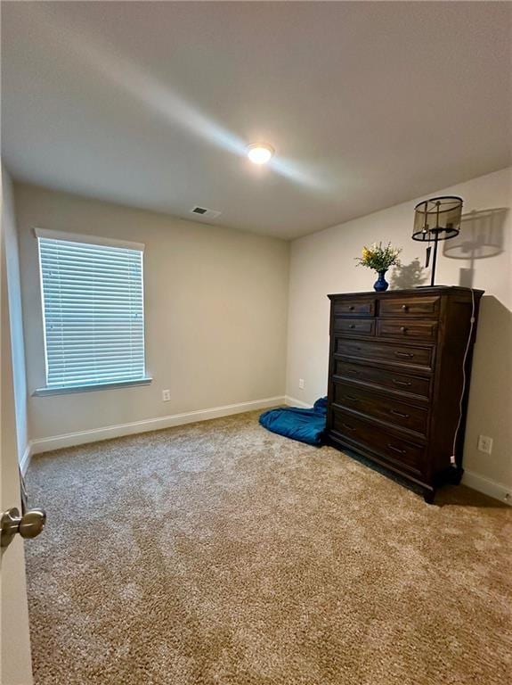 carpeted bedroom featuring baseboards and visible vents