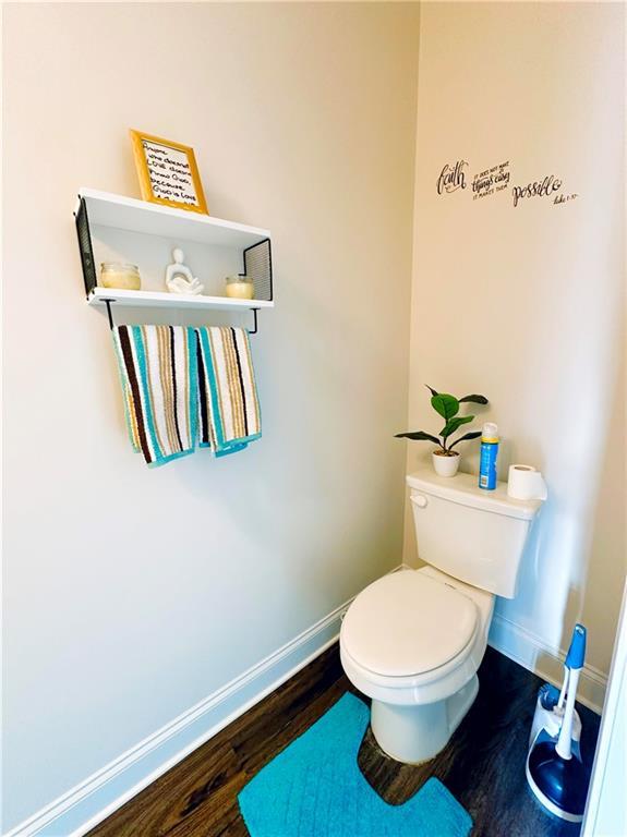 bathroom with baseboards, toilet, and wood finished floors