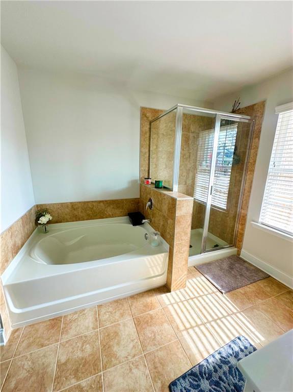 bathroom featuring vanity, tile patterned flooring, and plus walk in shower