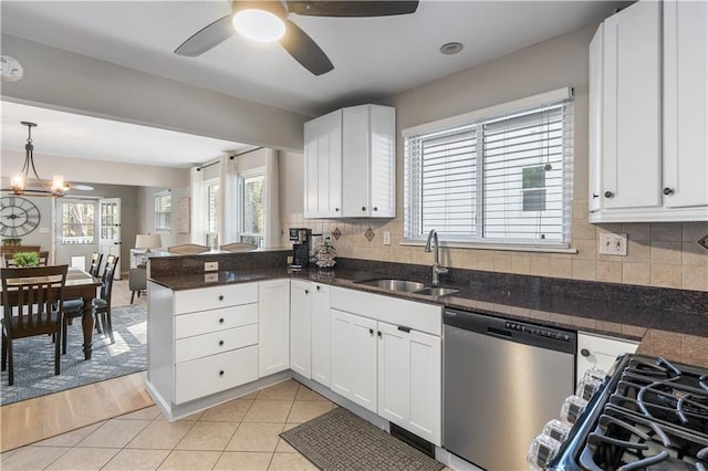 kitchen featuring dishwasher, a peninsula, white cabinets, and a sink