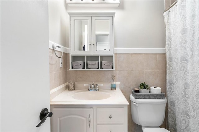 bathroom with toilet, curtained shower, vanity, and tile walls