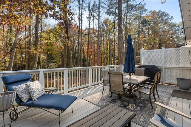 wooden deck featuring grilling area and outdoor dining area