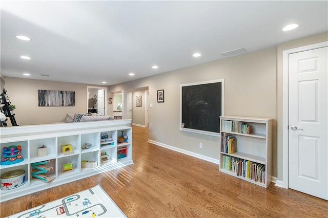 game room featuring recessed lighting, baseboards, and wood finished floors