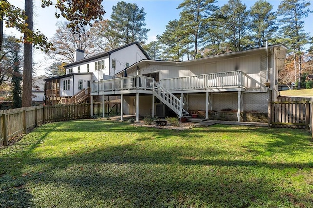 rear view of house featuring a deck, stairway, and a fenced backyard