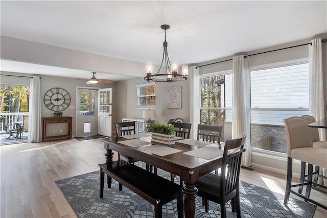 dining room featuring baseboards, light wood-style floors, and a healthy amount of sunlight