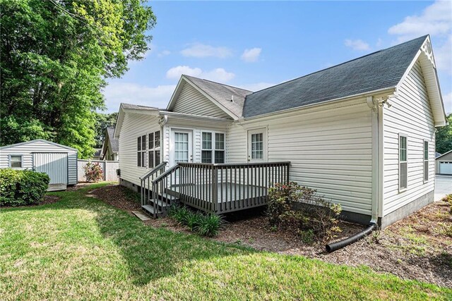 138 Victoria Ln, Lavonia, GA 30553 - rear view of house featuring roof with shingles, a lawn, a deck, an outbuilding, and a storage unit