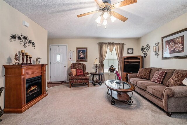 138 Victoria Ln, Lavonia, GA 30553 - carpeted living room featuring a glass covered fireplace, ceiling fan, and a textured ceiling