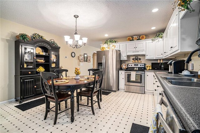 138 Victoria Ln, Lavonia, GA 30553 - kitchen with white cabinets, dark countertops, appliances with stainless steel finishes, an inviting chandelier, and under cabinet range hood