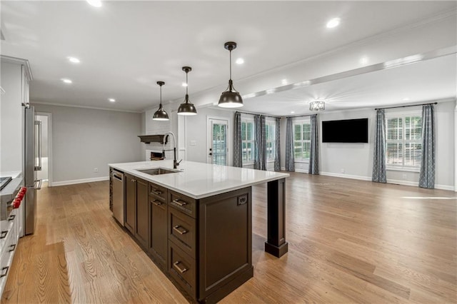 kitchen featuring a wealth of natural light, sink, pendant lighting, and light wood-type flooring