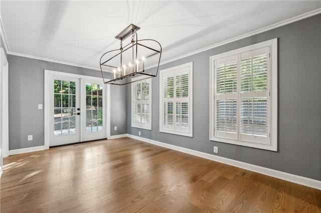 unfurnished dining area featuring french doors, hardwood / wood-style floors, plenty of natural light, and crown molding