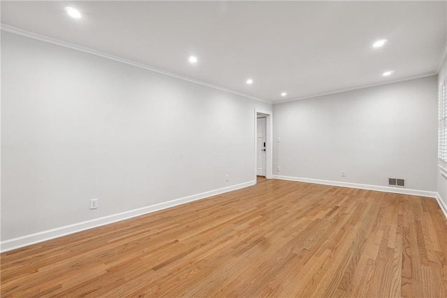 empty room featuring light hardwood / wood-style floors and ornamental molding