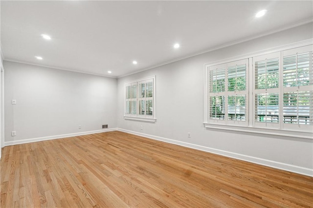 unfurnished room featuring ornamental molding and light wood-type flooring