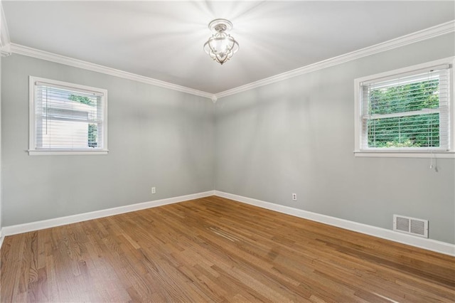 unfurnished room with ornamental molding and hardwood / wood-style floors