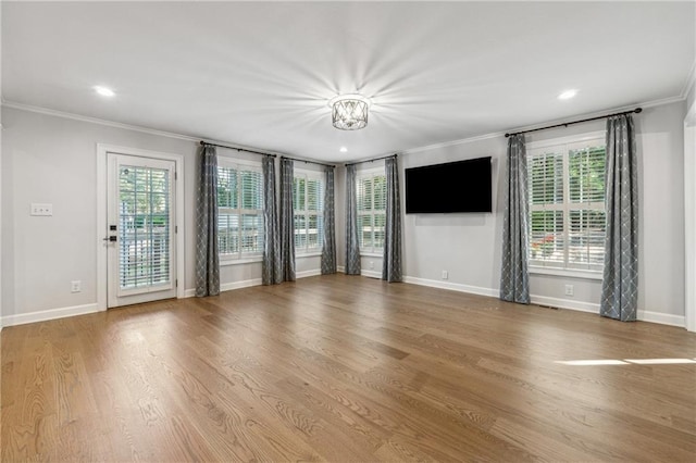 unfurnished living room with ornamental molding and hardwood / wood-style floors