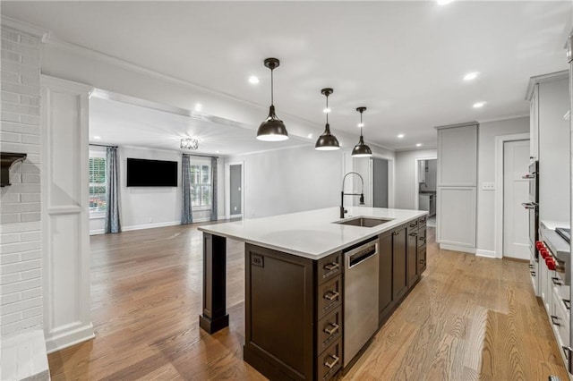 kitchen with hanging light fixtures, a kitchen island with sink, light wood-type flooring, dishwasher, and dark brown cabinetry