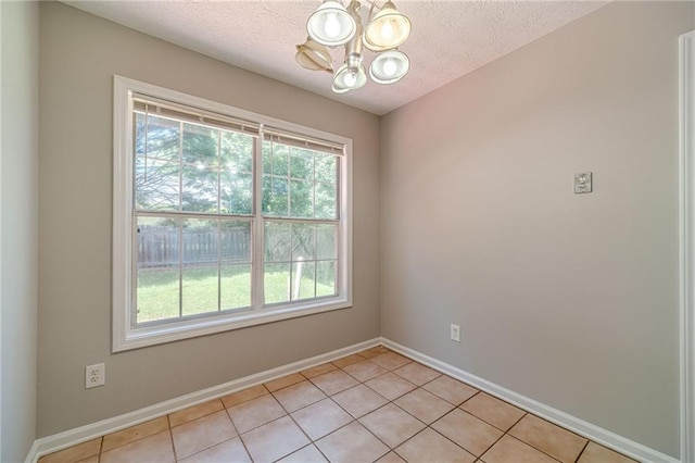 647 New England Way, Lawrenceville, GA 30046 - unfurnished room featuring a chandelier, healthy amount of natural light, baseboards, light tile patterned floors, and a textured ceiling