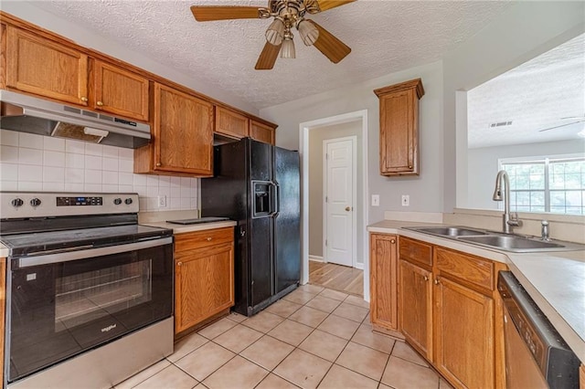 647 New England Way, Lawrenceville, GA 30046 - kitchen with stainless steel appliances, under cabinet range hood, a sink, a textured ceiling, and decorative backsplash