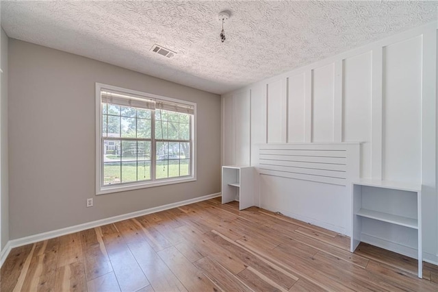 647 New England Way, Lawrenceville, GA 30046 - unfurnished room featuring light wood-style flooring, a textured ceiling, and baseboards