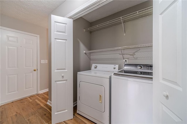 647 New England Way, Lawrenceville, GA 30046 - laundry room with washer and dryer, light wood-type flooring, and a textured ceiling