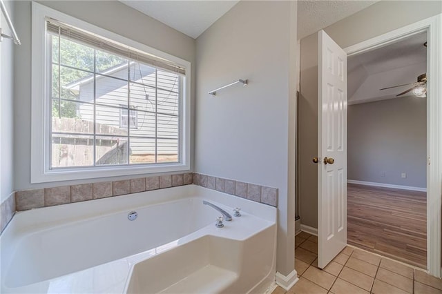 647 New England Way, Lawrenceville, GA 30046 - bathroom with tile patterned flooring, a bath, ceiling fan, and baseboards