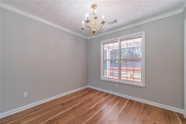 647 New England Way, Lawrenceville, GA 30046 - unfurnished room with a chandelier, hardwood / wood-style flooring, baseboards, a textured ceiling, and crown molding