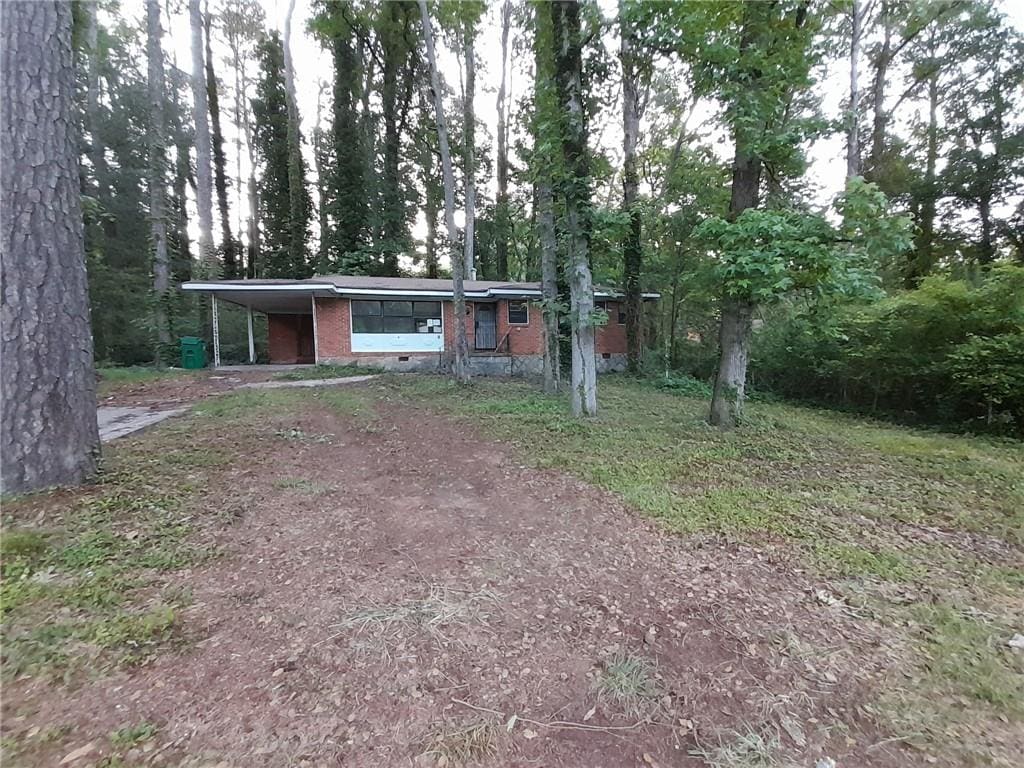 3252 Pinehill Dr, Decatur, GA 30032 - view of front of home featuring dirt driveway, brick siding, and a carport