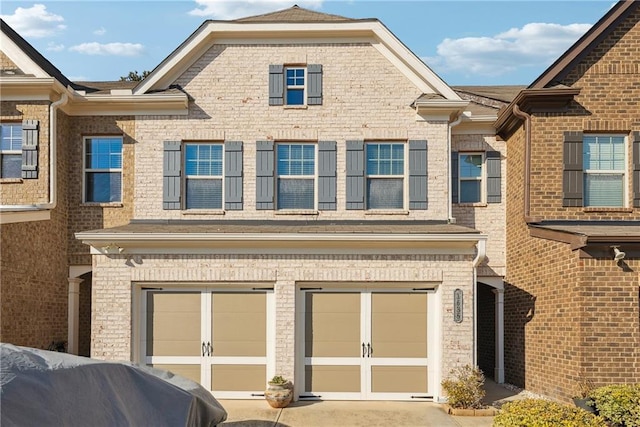 exterior space featuring a garage, driveway, and brick siding