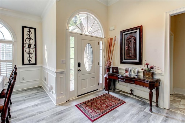 entryway featuring light wood-type flooring and ornamental molding