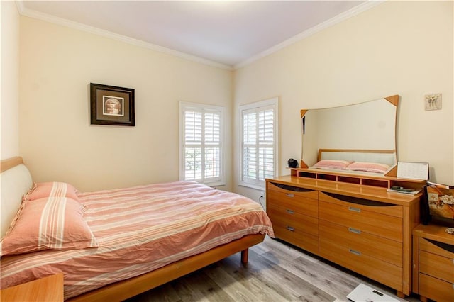 bedroom featuring light wood-type flooring and crown molding