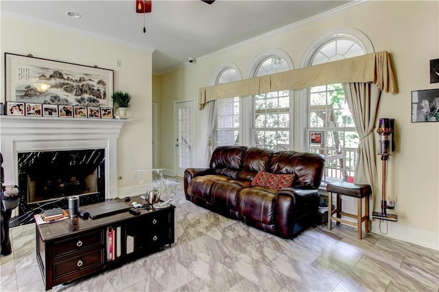 living room with ceiling fan, a premium fireplace, and ornamental molding