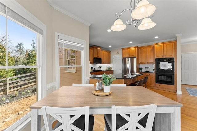 dining area featuring recessed lighting, light wood-style flooring, an inviting chandelier, and ornamental molding