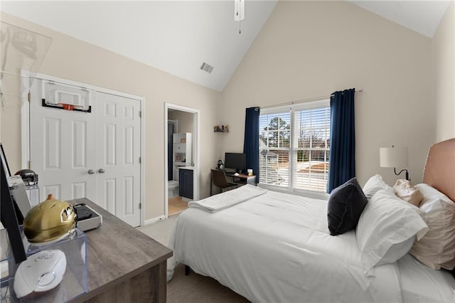 bedroom featuring visible vents, connected bathroom, light colored carpet, a closet, and high vaulted ceiling