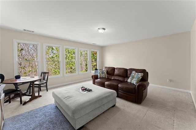 living area with visible vents, baseboards, and light carpet