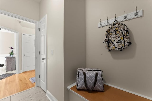 corridor featuring tile patterned floors and baseboards