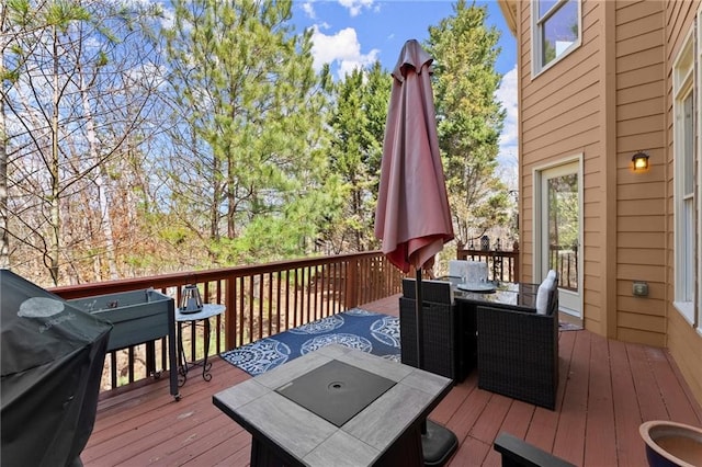 wooden deck with outdoor dining space and area for grilling