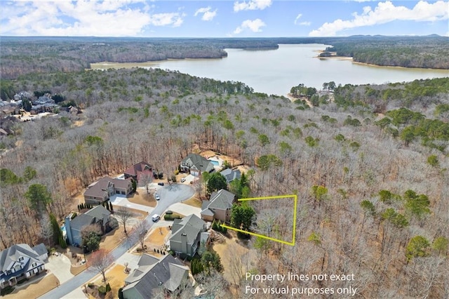 drone / aerial view with a forest view and a water view