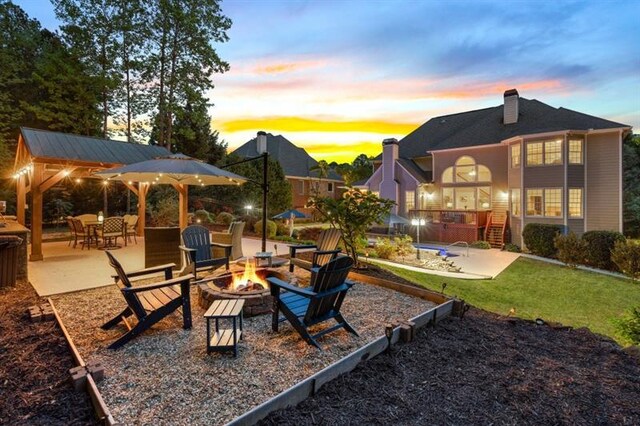 2439 Huntington Park Dr NW, Acworth, GA 30101 - playground at dusk with a lawn, a patio, and an outdoor fire pit