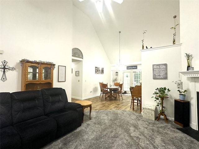 living room featuring wood-type flooring and high vaulted ceiling