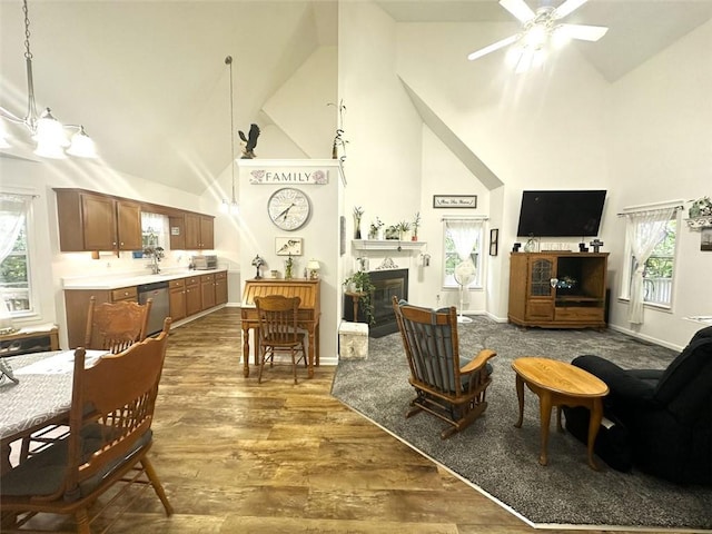 living room featuring dark hardwood / wood-style flooring, plenty of natural light, high vaulted ceiling, and ceiling fan