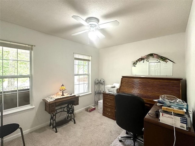 office space featuring ceiling fan, light colored carpet, and a textured ceiling