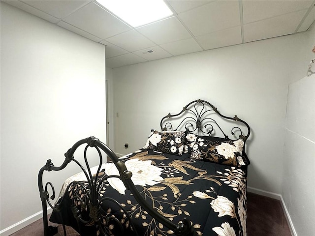 bedroom featuring a paneled ceiling and dark carpet