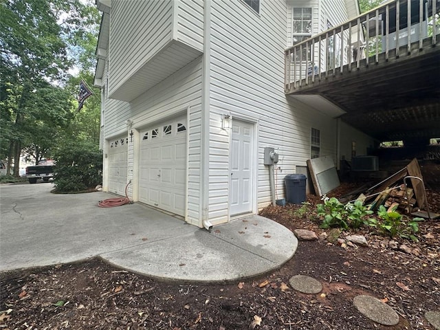 view of property exterior featuring cooling unit, a balcony, and a garage