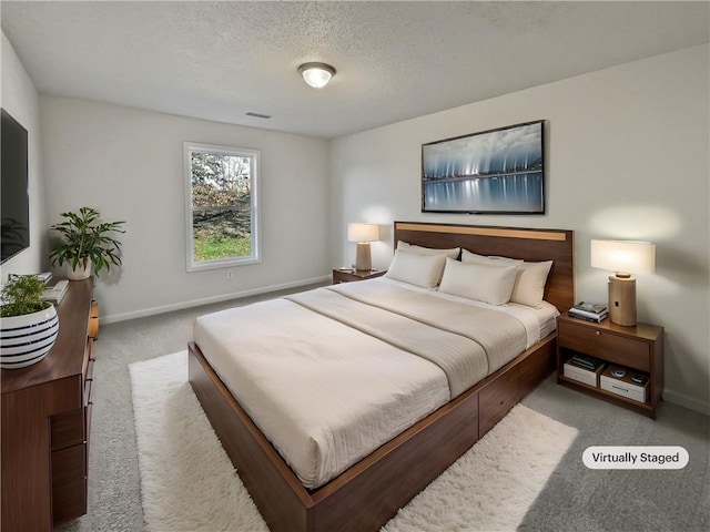 bedroom with baseboards, visible vents, a textured ceiling, and light colored carpet