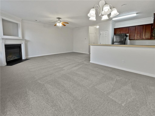 unfurnished living room with carpet floors, crown molding, a fireplace with flush hearth, baseboards, and ceiling fan with notable chandelier