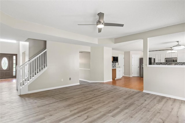 unfurnished living room featuring light hardwood / wood-style flooring and ceiling fan