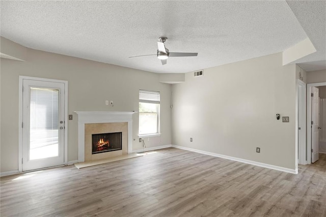 unfurnished living room featuring light hardwood / wood-style flooring, a textured ceiling, and ceiling fan