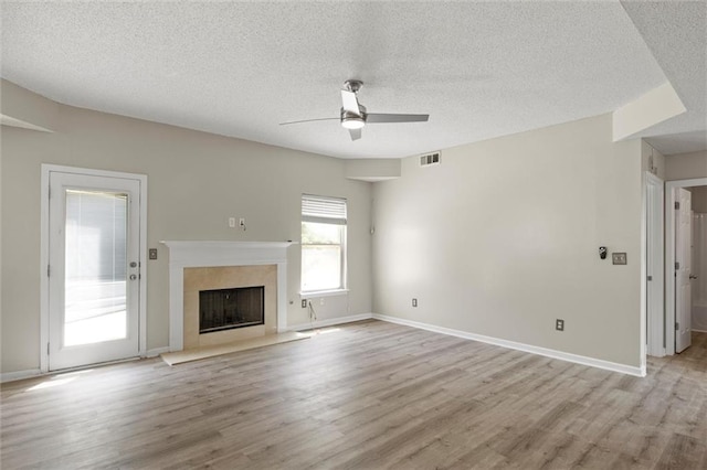 unfurnished living room featuring light hardwood / wood-style flooring, a textured ceiling, and ceiling fan